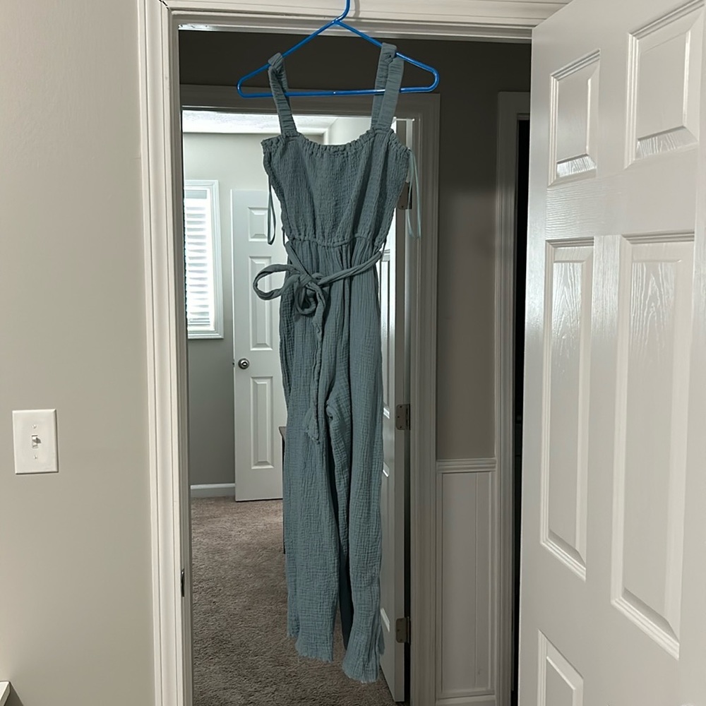 Teal jumpsuit. Ties around the waist and has an open back.